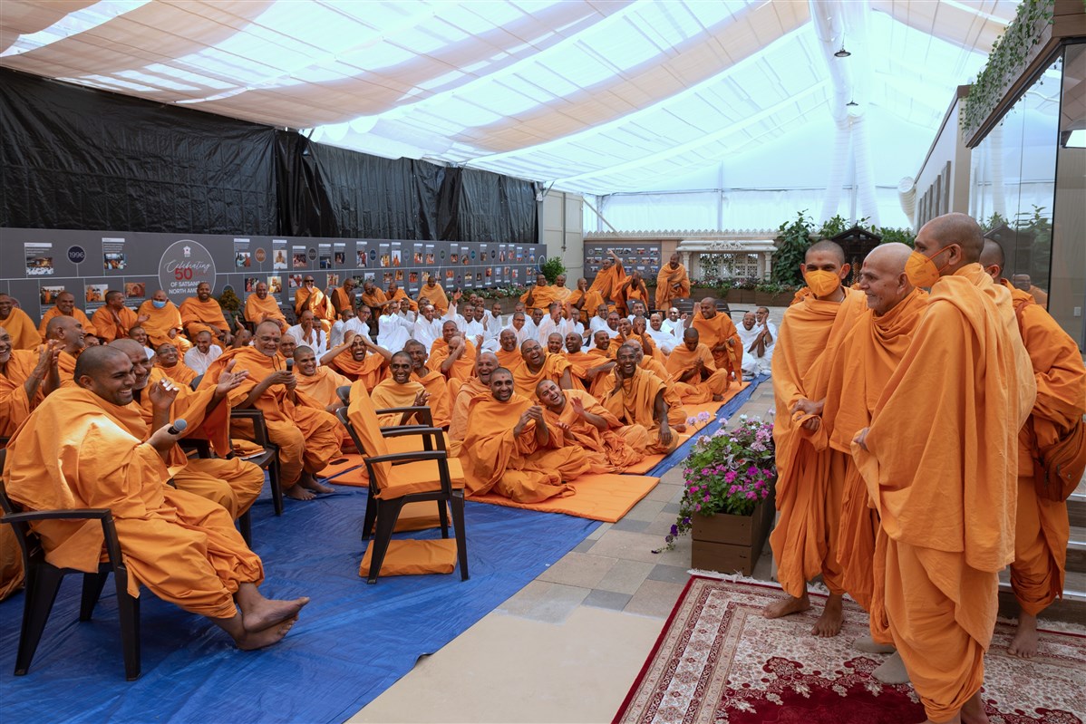 Swamis share a light moment with Swamishri after the afternoon assembly