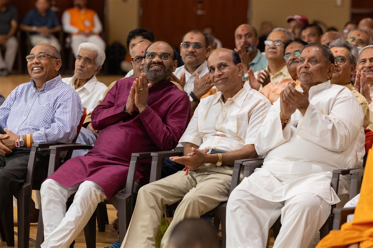 Devotees enjoy a light-hearted moment during the assembly