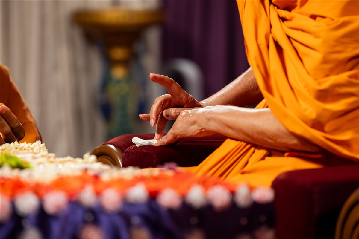 Swamishri wipes his finger after applying tilak