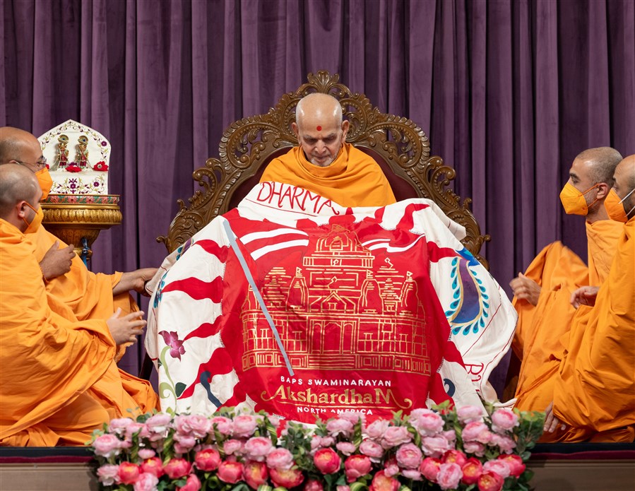 Swamis present a shawl to Swamishri