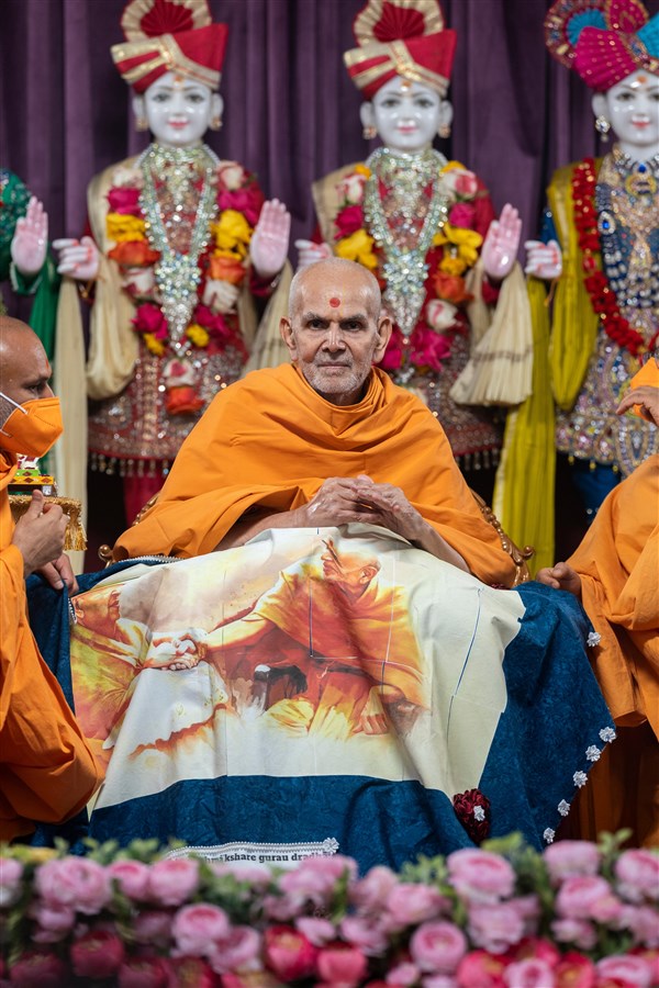 A shawl is presented to Swamishri