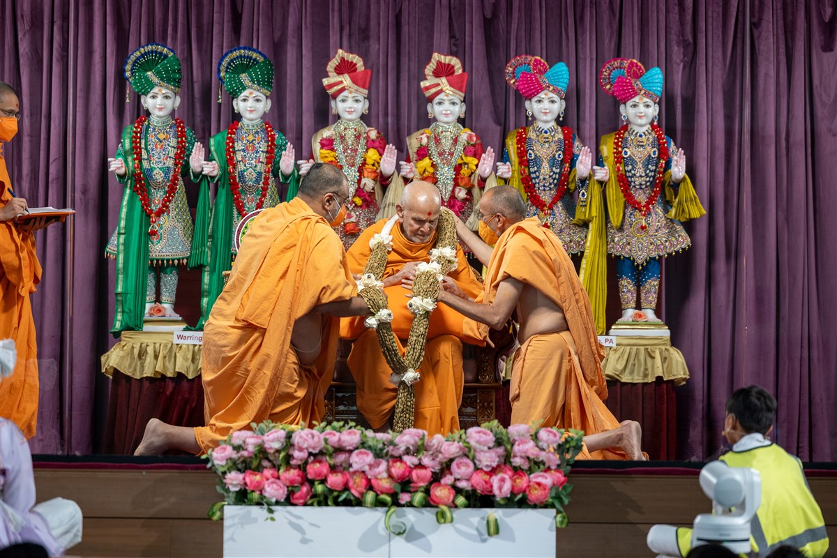 Swamishri is presented with a cardamom garland
