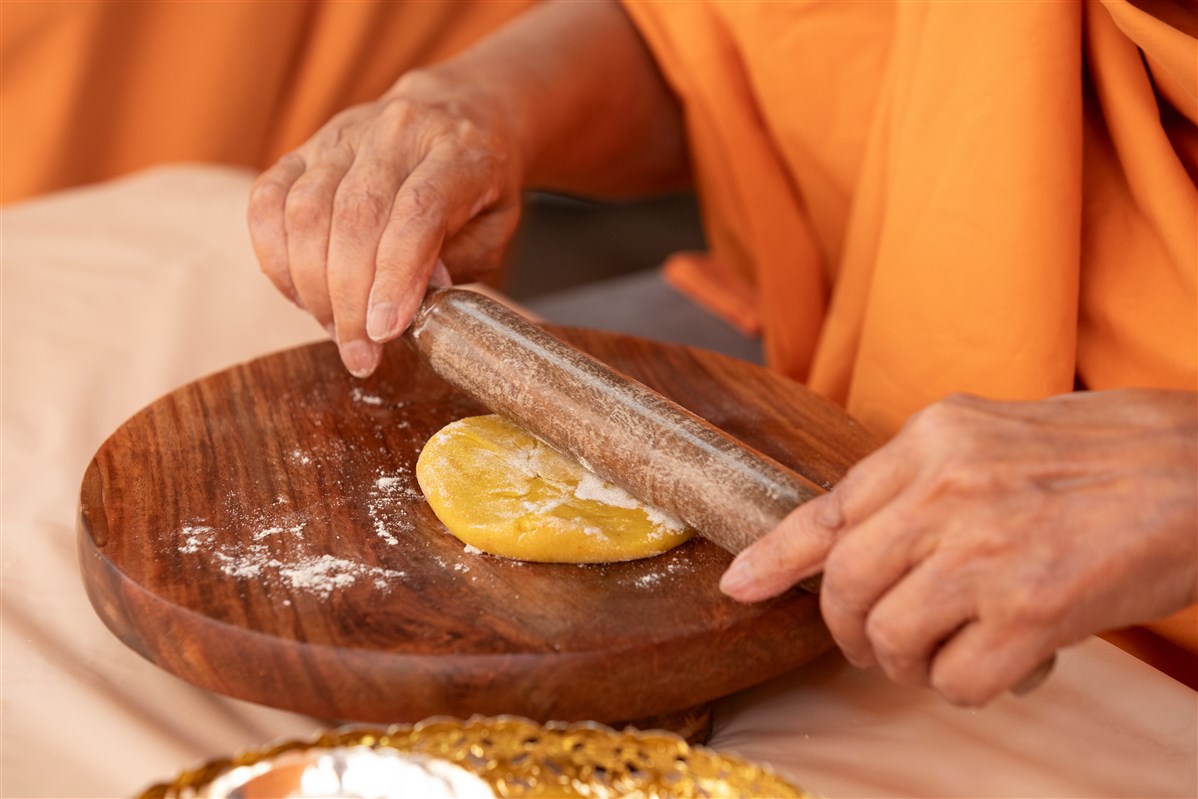 Swamishri rolls the dough