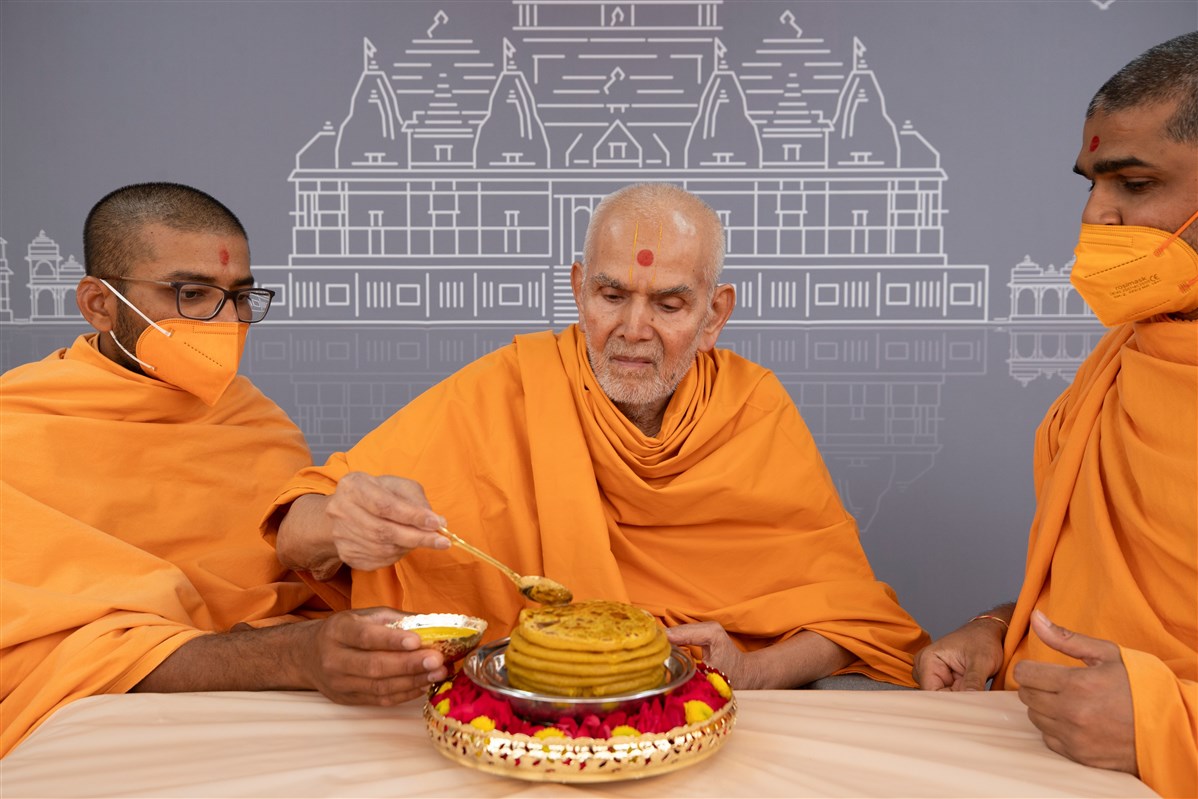Swamishri applies ghee to the puran poli