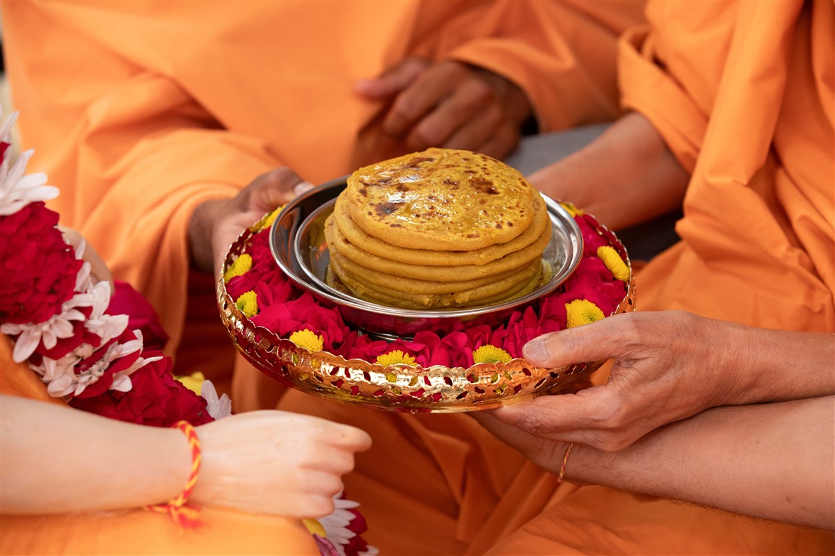 Swamishri offers the puran poli to the murti of Pramukh Swami Maharaj