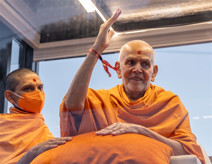Swamishri gestures to the volunteers