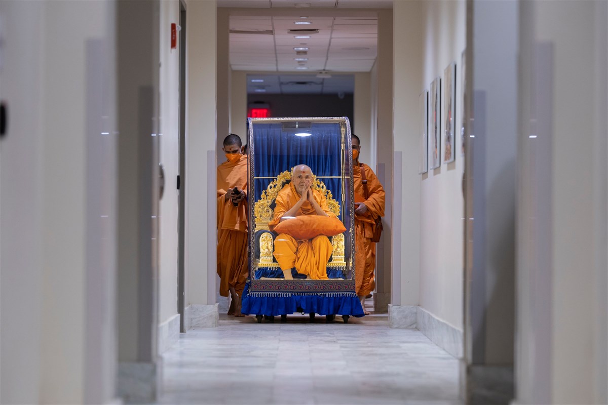 Swamishri's folded hands in devotee-less hallways epitomize his innate humility