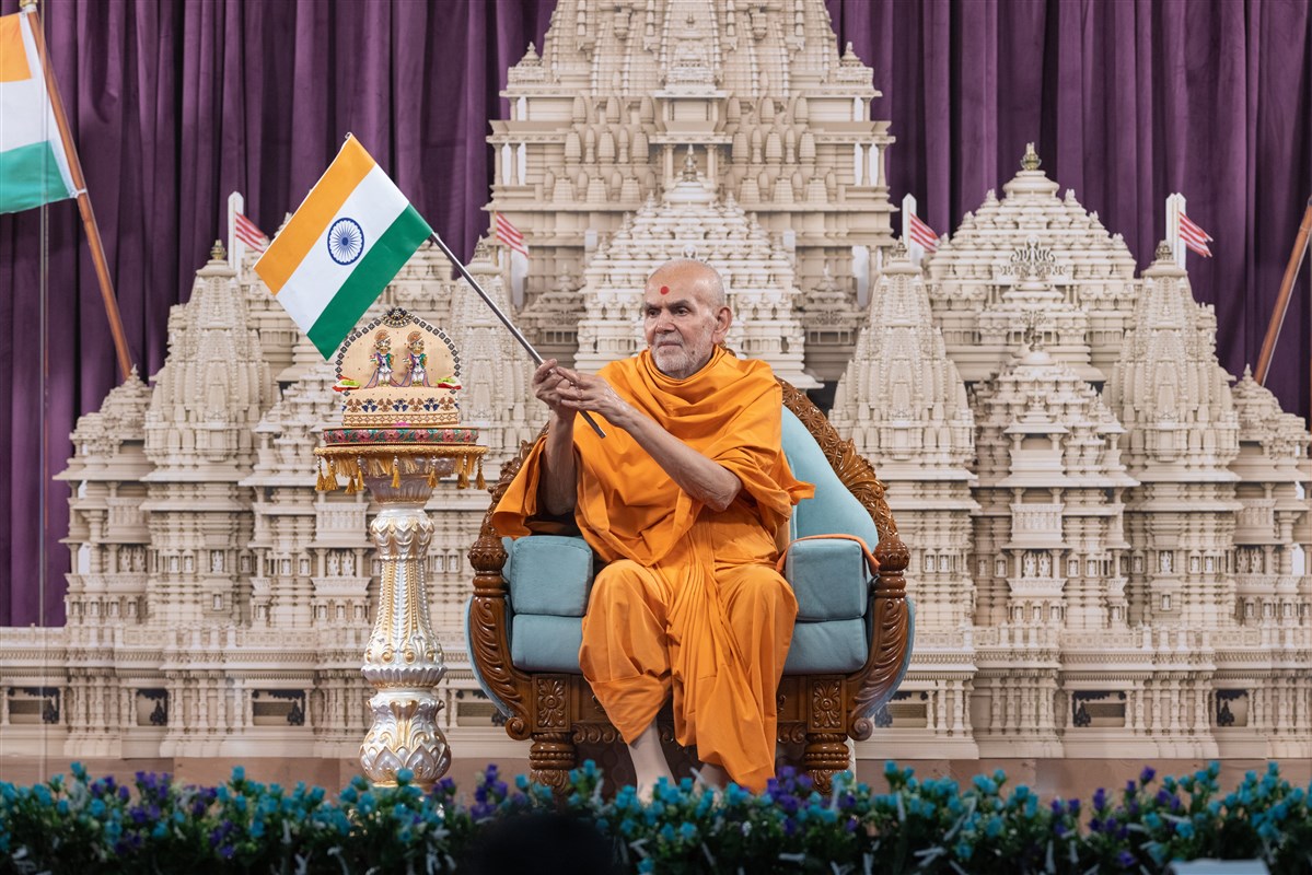 Swamishri waves the national flag of India to celebrate the Indian Independence Day