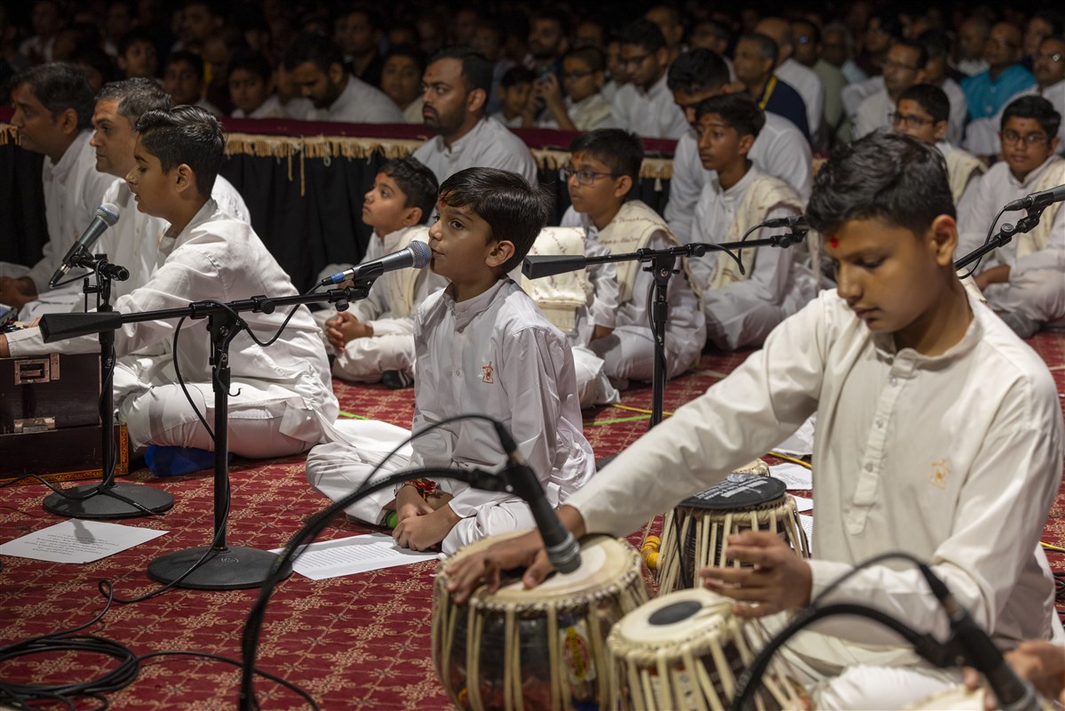 Children and youth offer kirtan bhakti during Swamishri’s puja