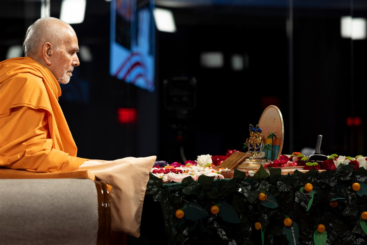 Swamishri turns the mala during the puja