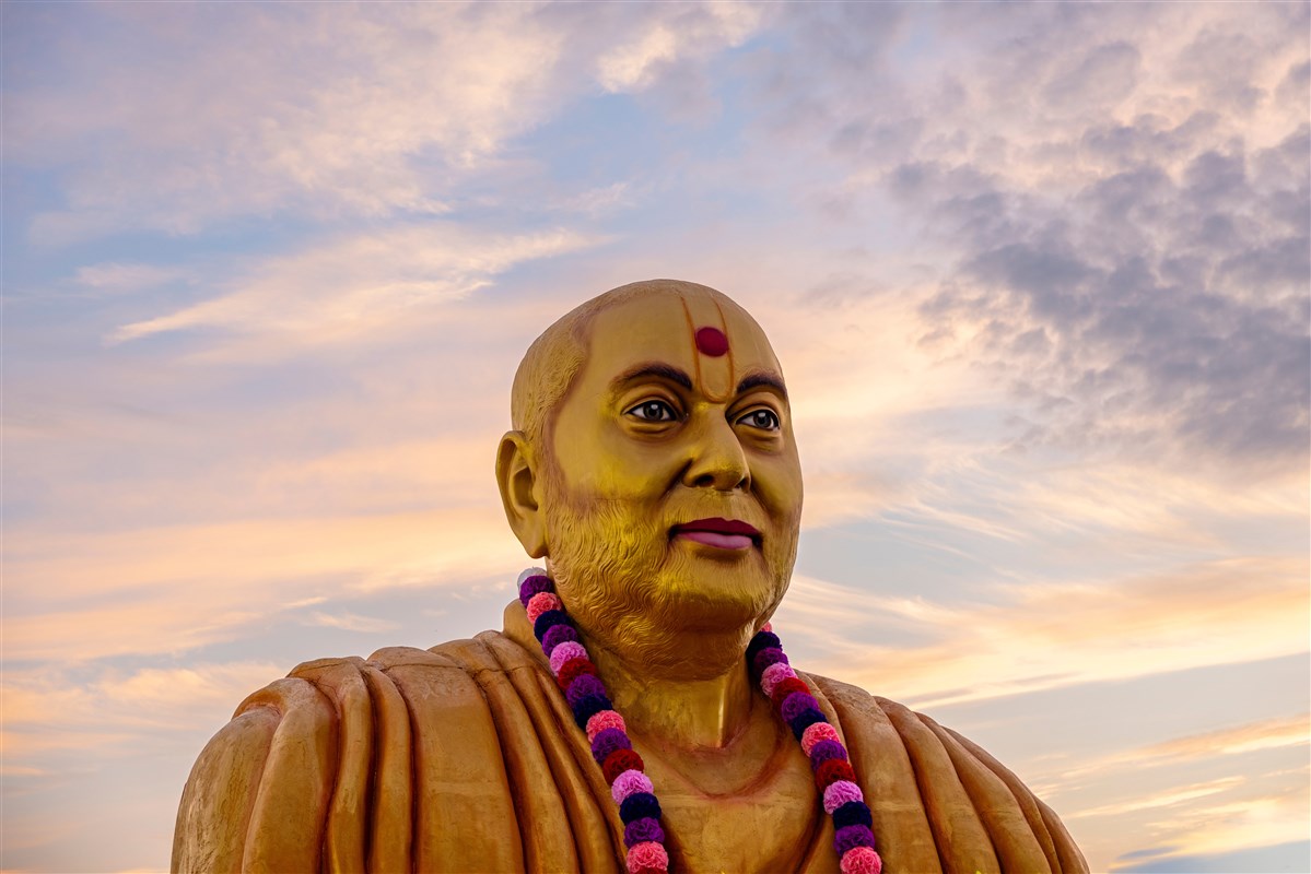 In the gentle embrace of dawn, the murti of Pramukh Swami Maharaj graces Swaminarayan Nagar