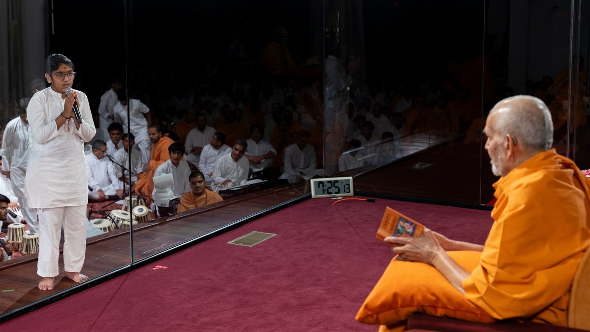 Swamishri attentively listens to a child's presentation