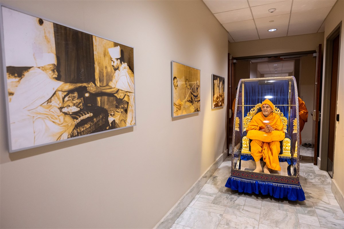 Swamishri views his Guru's photos en route to puja
