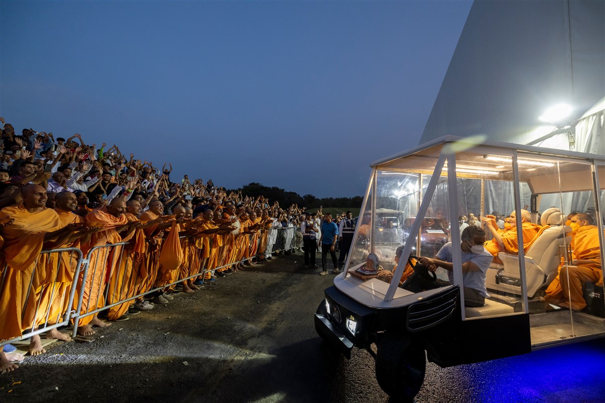 Swamishri greets devotees & skit performers on his way from the evening assembly
