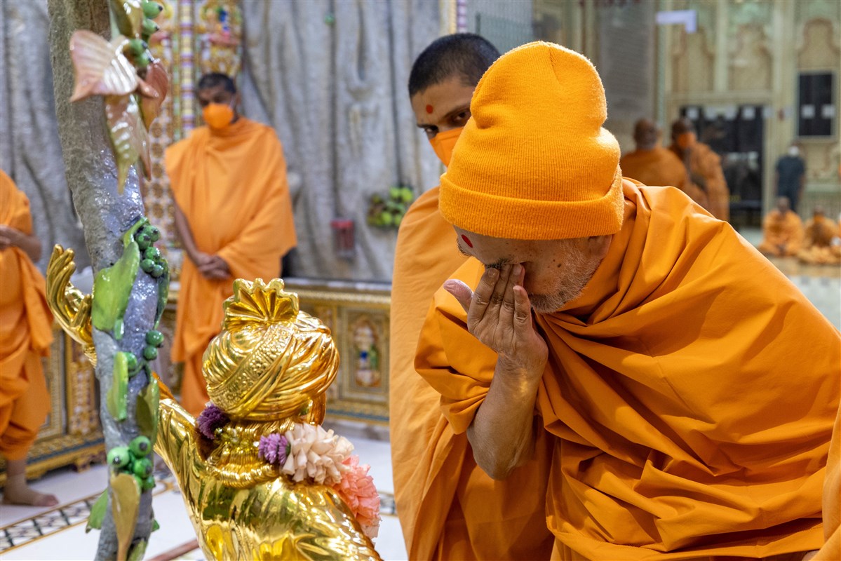 Swamishri touches his eyes after touching the feet of Shri Ghanshyam Maharaj in a moment of reverence