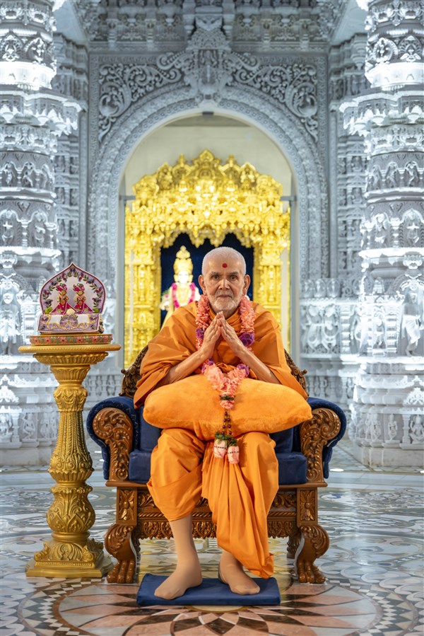 Swamishri with folded hands after being garlanded