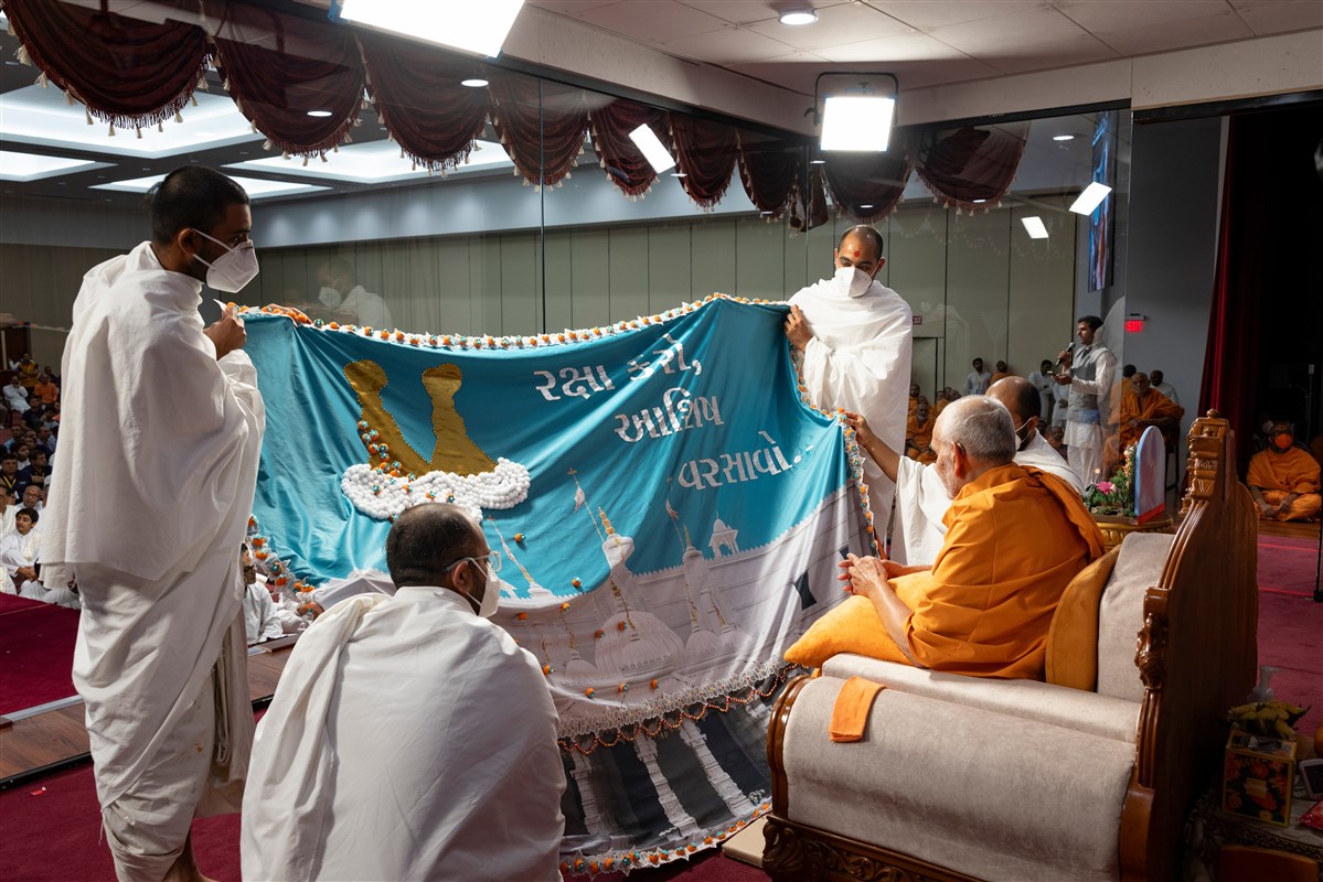 Swamishri observes a decorative shawl