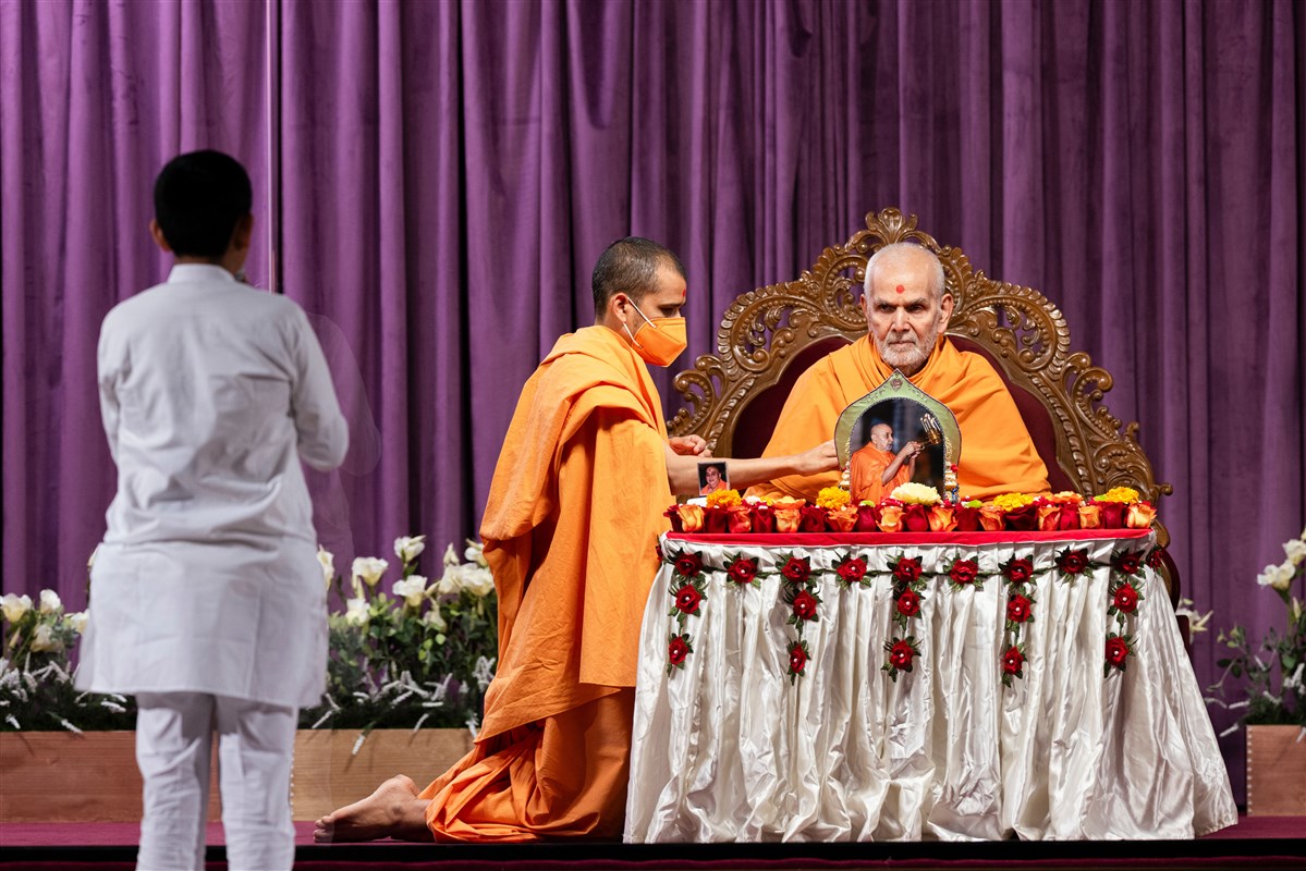 A child recites various scriptural passages in Swamishri's puja