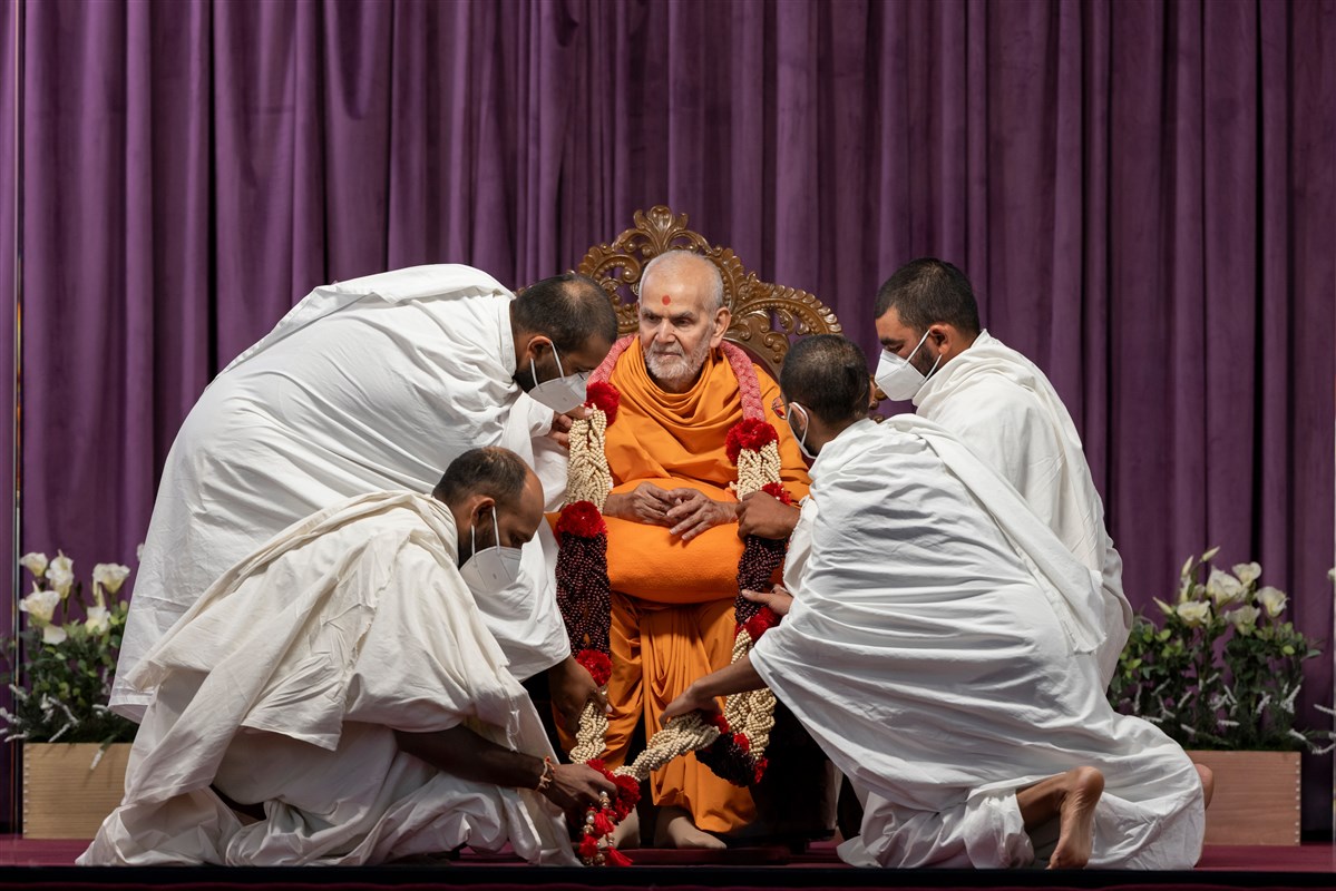 Parshads present Swamishri with a garland