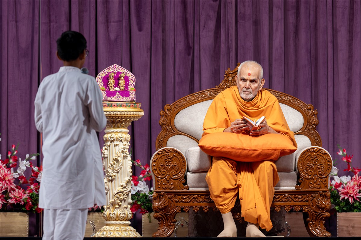 Swamishri listens to a child's recitation