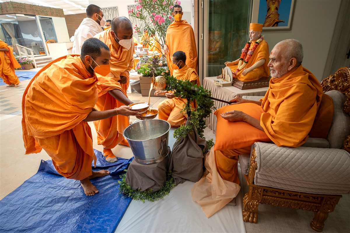 Swamishri serves a sweet dessert called basundi to swamis after the afternoon assembly