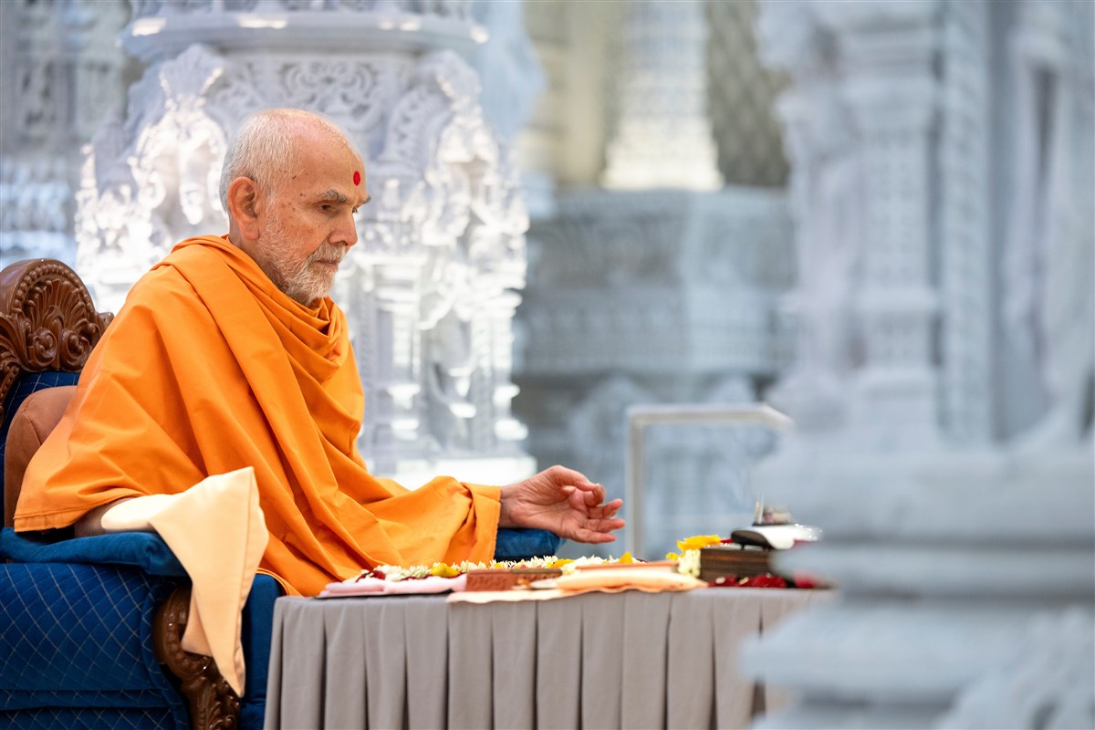 Swamishri turns the mala during puja