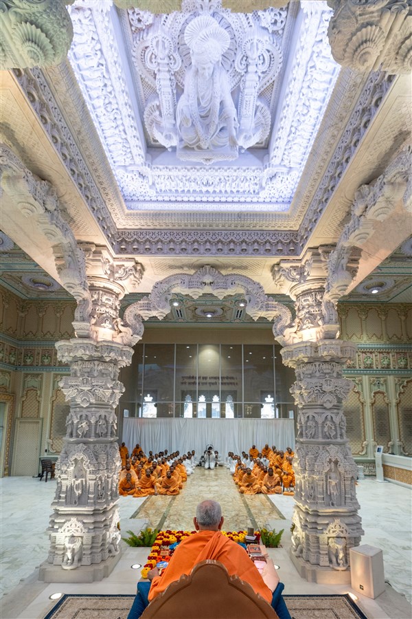 Swamishri performing puja under the murti of Bhagwan Swaminarayan 
