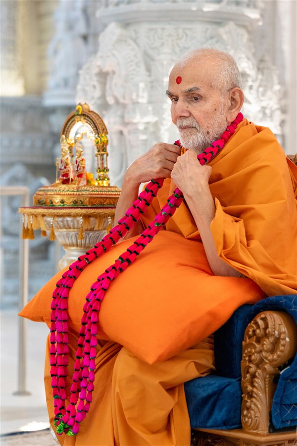 Swamishri adorned with a garland