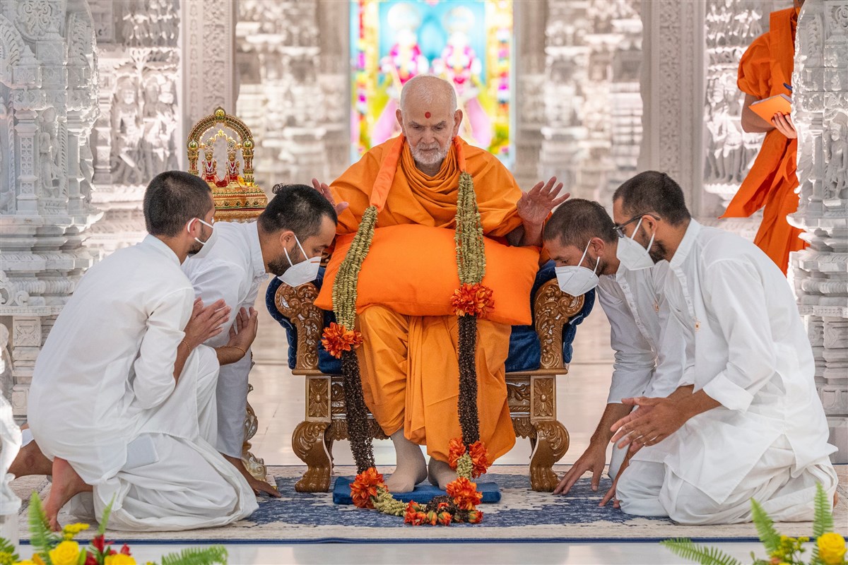 Swamishri blesses sadhaks after they garland him