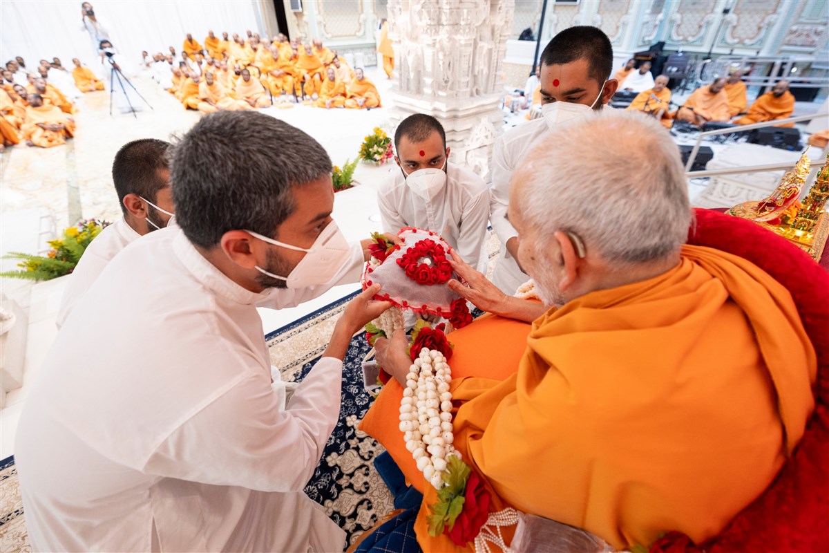 Swamishri observes the garland presented to him