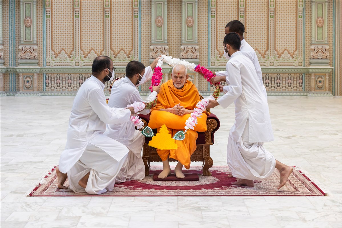 Sadhaks offer Swamishri with a garland