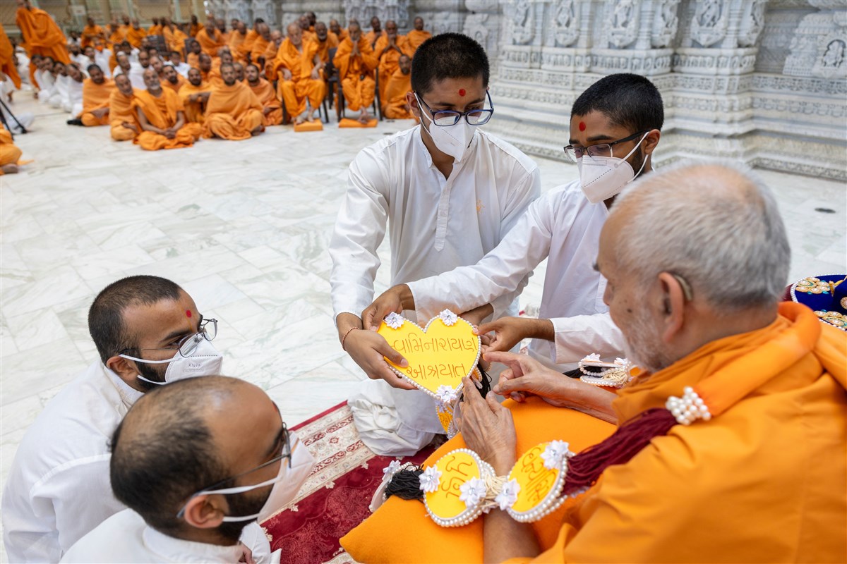 Sadhaks offer Swamishri with a garland