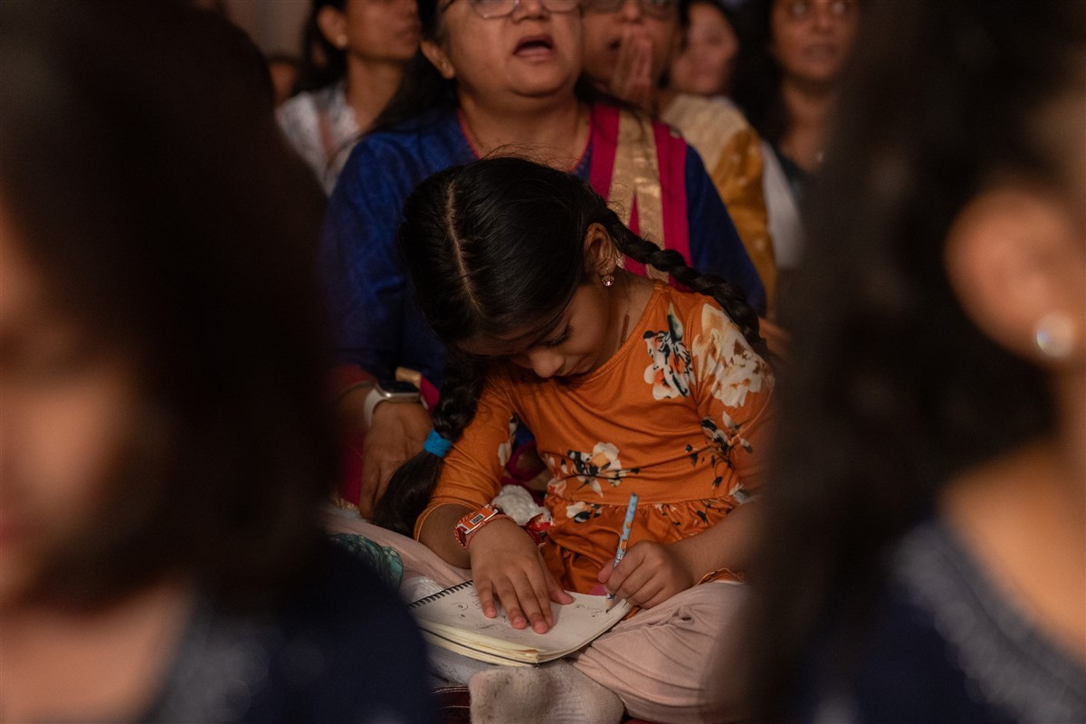A child draws during puja