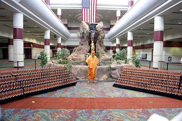 Swamishri in front of a large murti of Neelkanth Varni as well as smaller murtis to be given out as mementos