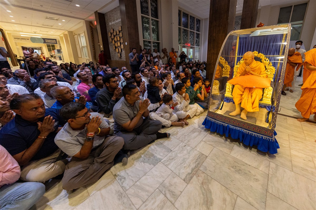 Swamishri greets children and devotees with folded hands