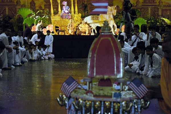 Evening ,Swamishri controls a remote-controlled Rath with Shri Harikrishna Maharaj in it 	