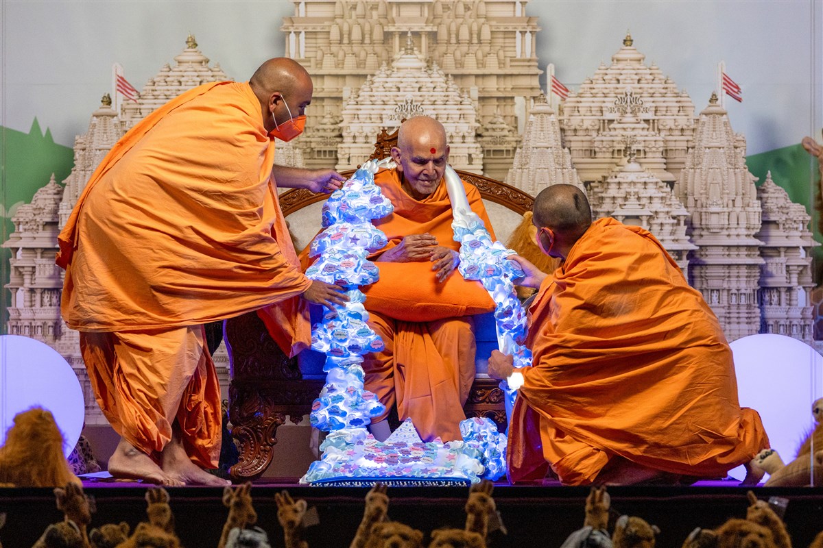 Swamis offer a garland to Swamishri