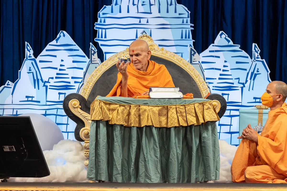 Swamishri offers cupcakes to all the children
