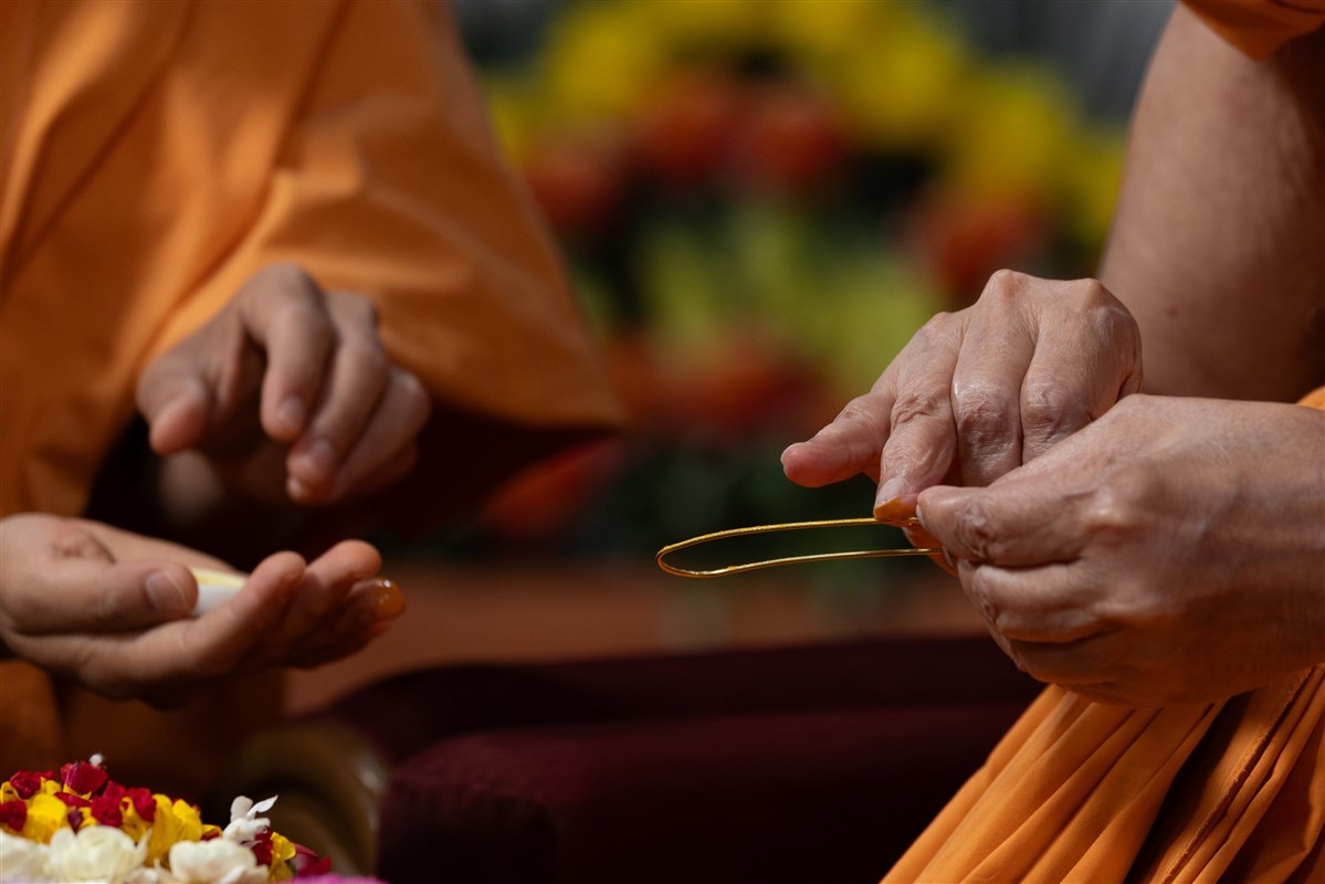 Swamishri applies sandalwood paste for the tilak