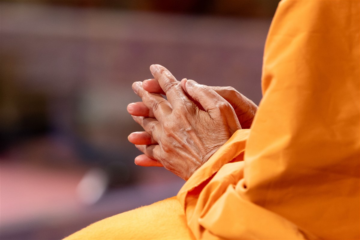 Swamishri speaks earnestly with hands folded