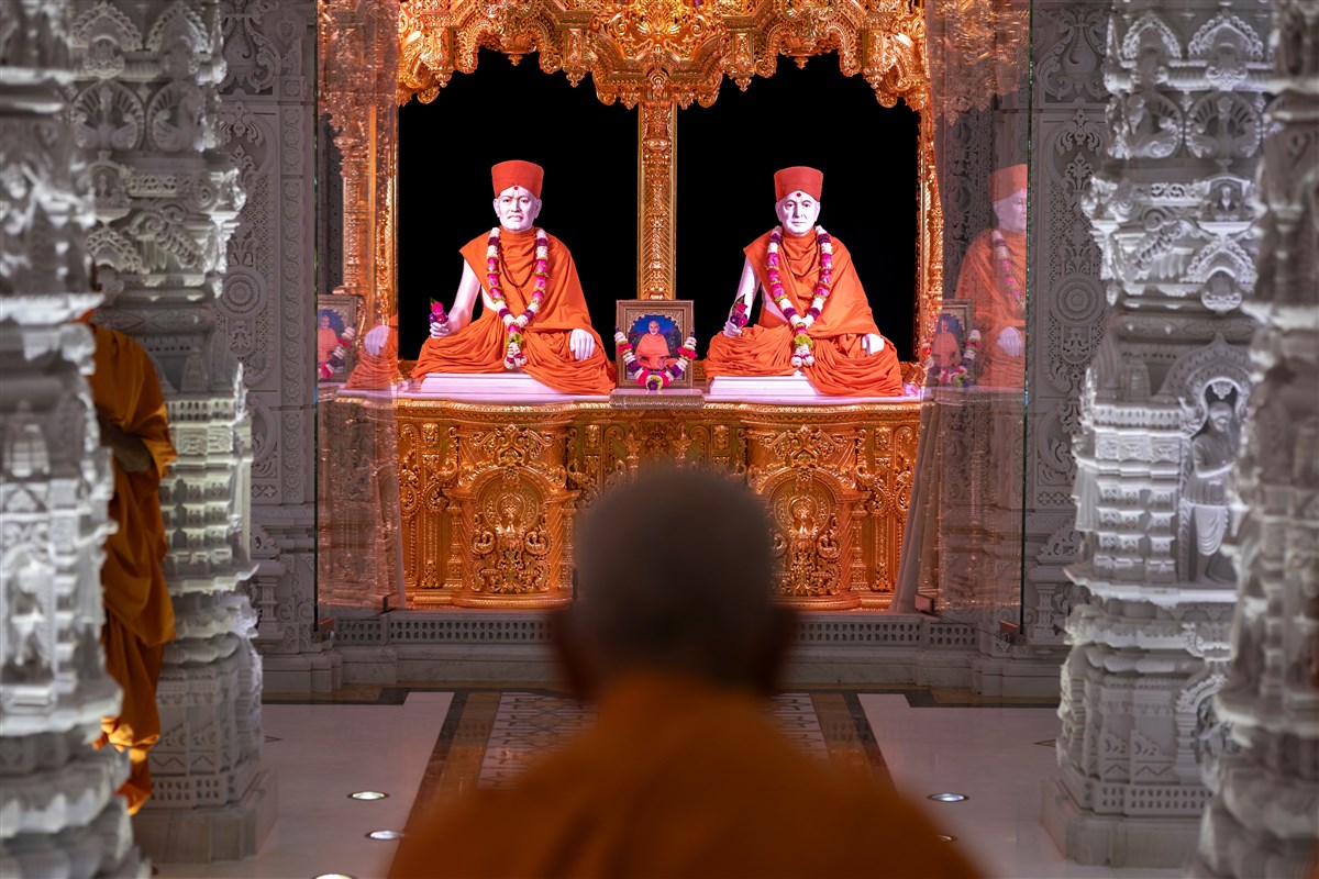 Swamishri engrossed in the darshan of Brahmaswarup Shastriji Maharaj and Brahmaswarup Pramukh Swami Maharaj