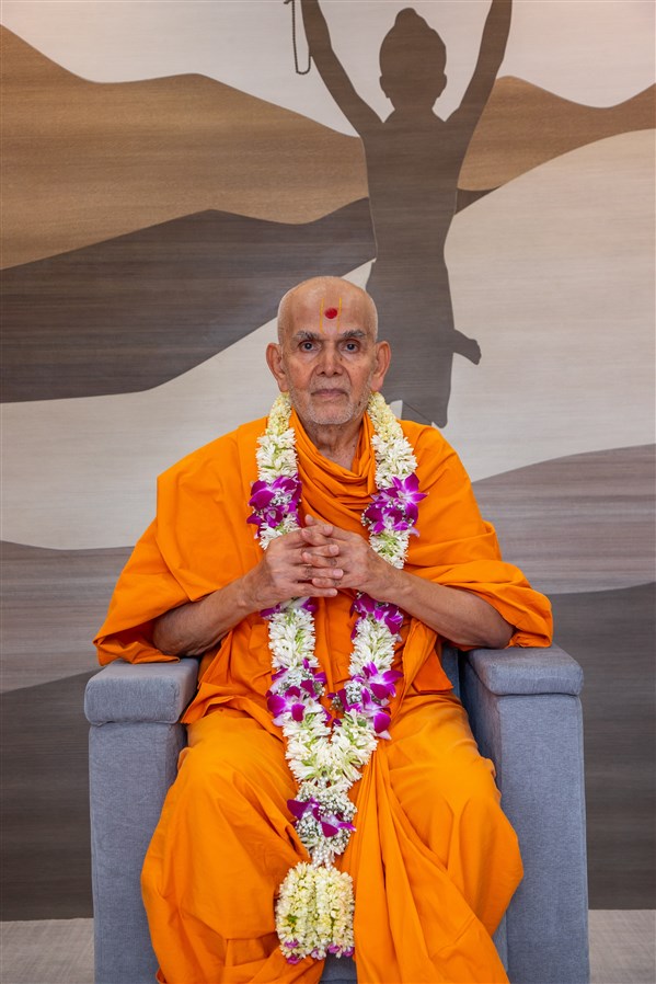 Swamishri adorned with a garland