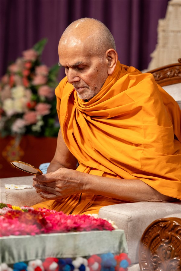 Swamishri does darshan of the murti of Pramukh Swami Maharaj behind the mirror