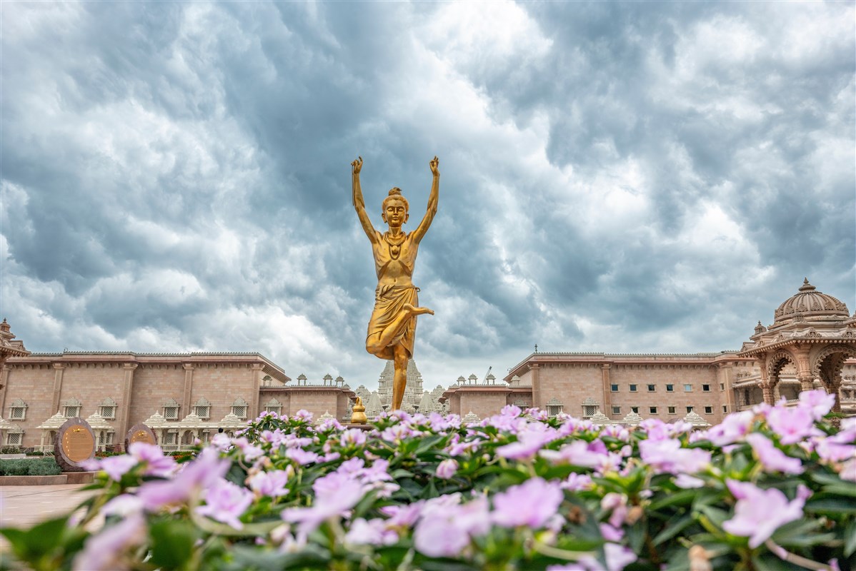 Tapomurti Shri Nilkanth Varni amidst blossoming flowers and brooding clouds