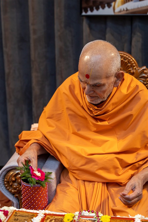 Swamishri adds flowers to the sanctified water