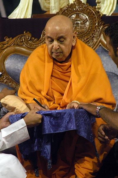 Swamishri fills out information in the "Vicharan" passports