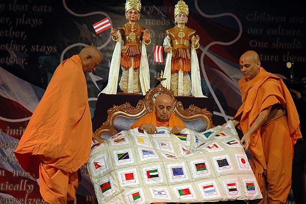 Swamishri is presented with a quilt representing different countries he has visited 