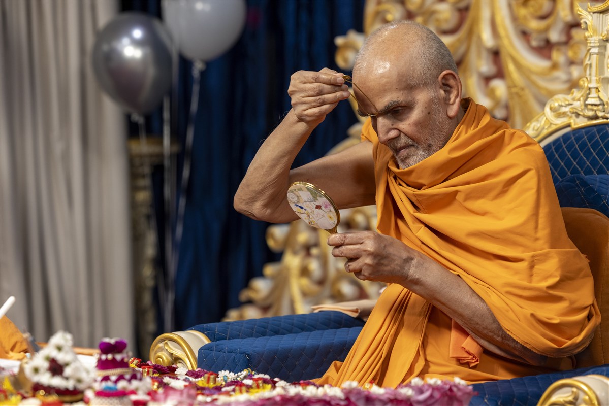 Swamishri applying a tilak on his forehead