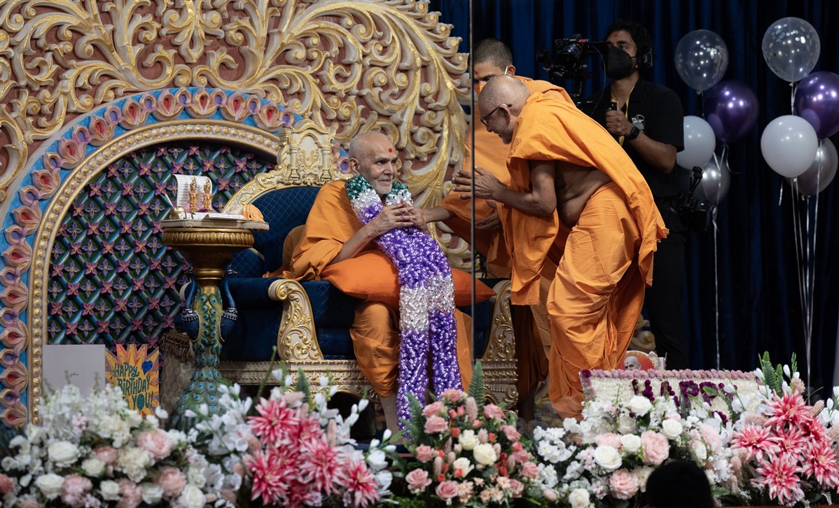 Sadguru Pujya Bhaktipriyadas Swami (Kothari Swami) garlands Swamishri