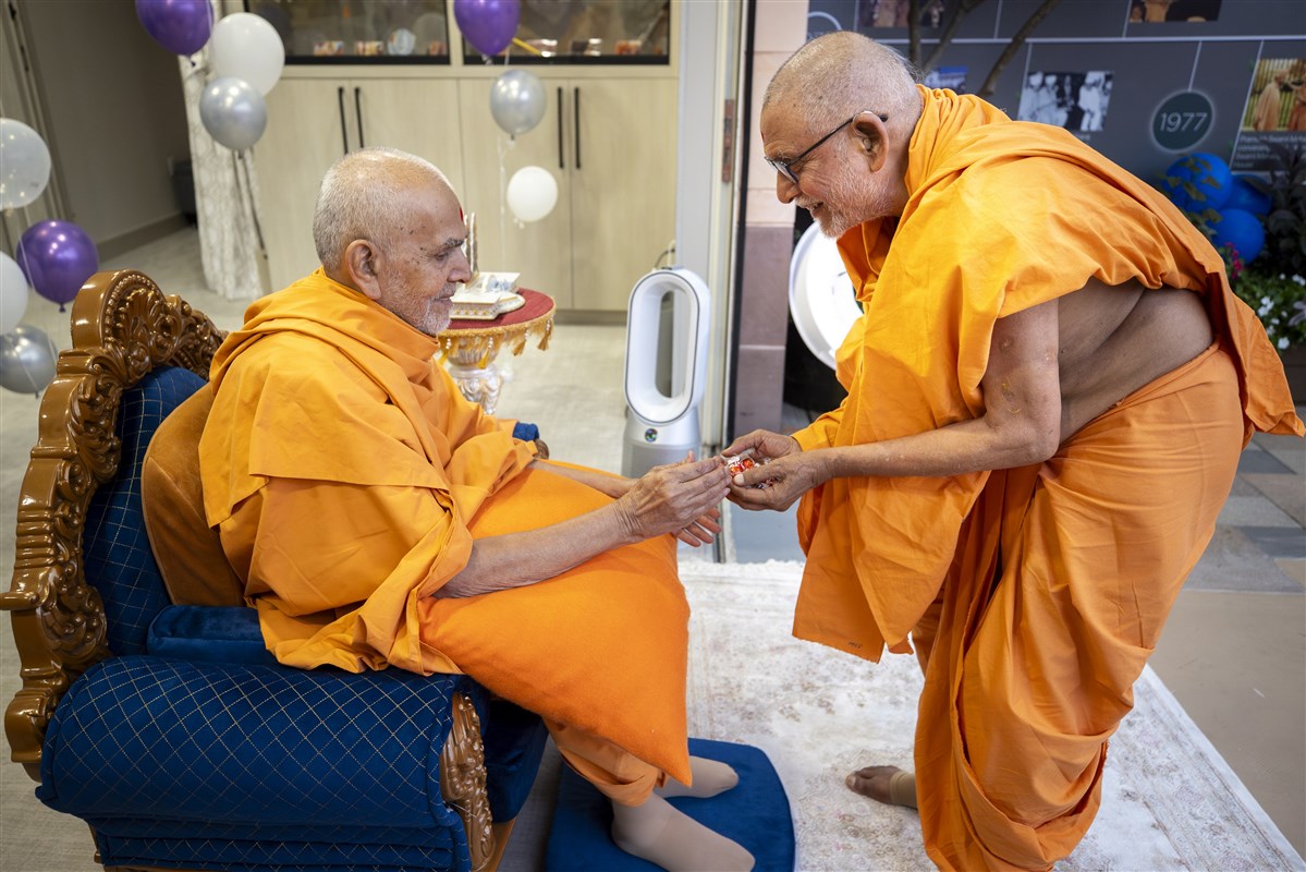 Sadguru Pujya Bhaktipriyadas Swami offers chocolates to Swamishri